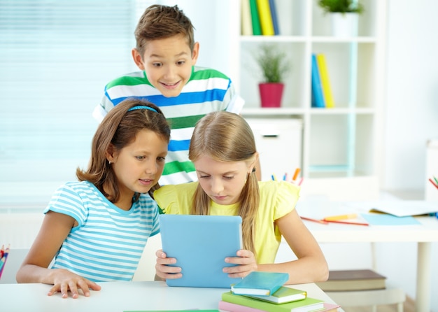 Estudantes que usam uma tabuleta digital na sala de aula