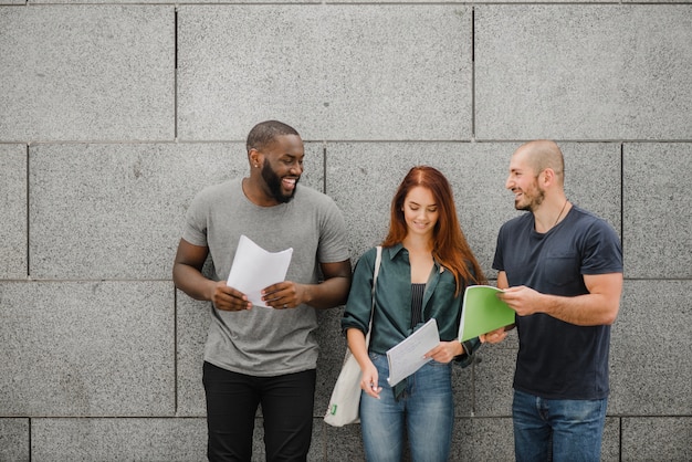 Foto grátis estudantes segurando cadernos sorrindo