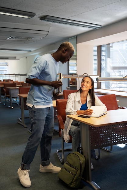 Estudantes universitários multirraciais sorridentes de tiro completo