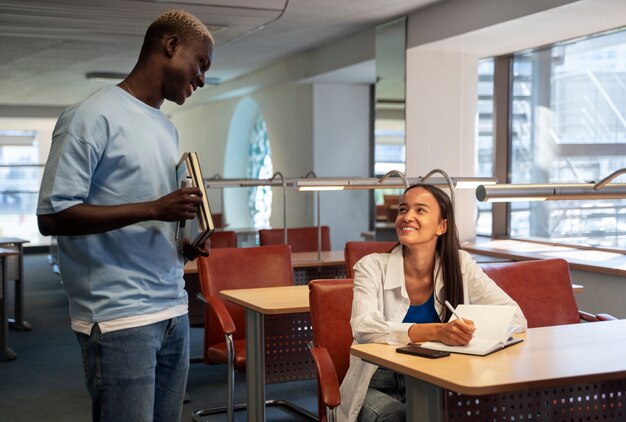 Estudantes universitários multirraciais sorridentes de tiro médio