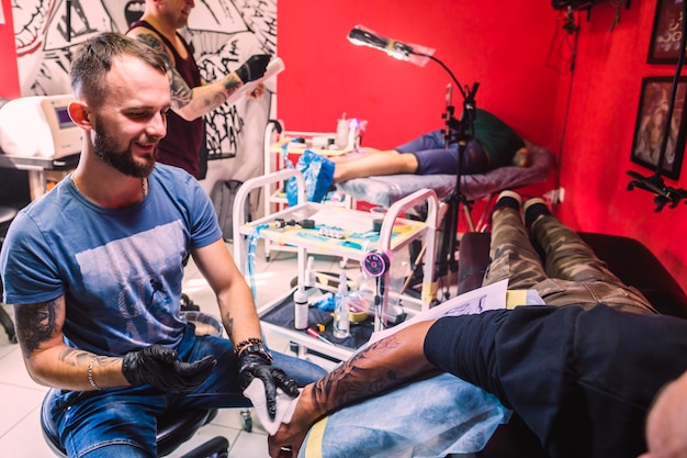 Estúdio de tatuagem com mestres e clientes