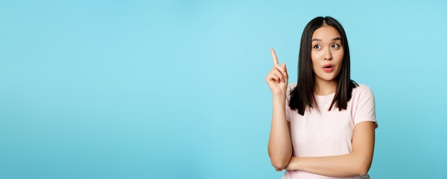 Foto grátis eureka jovem asiática encontrou solução menina coreana levantando o dedo e lançando uma ideia em pé