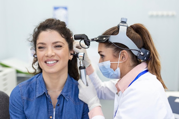 Exame auditivo Médico otorrinolaringologista verificando o ouvido da mulher usando otoscópio ou auriscópio na clínica médica