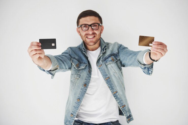 Foto grátis executivo de negócios masculino bonito jovem em traje casual, segurando um cartão de crédito nos bolsos em branco