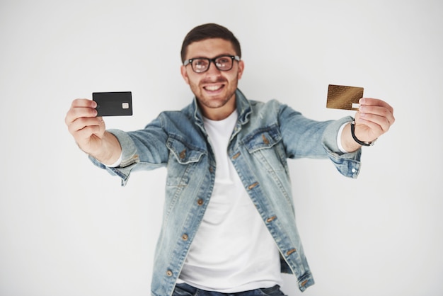 Executivo de negócios masculino bonito jovem em traje casual, segurando um cartão de crédito nos bolsos em branco