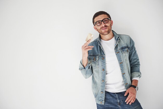 Executivo de negócios masculino bonito jovem em traje casual, segurando um cartão de crédito nos bolsos em branco