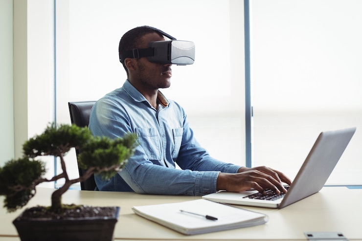 Foto grátis executivo de negócios usando fone de ouvido de realidade virtual e trabalhando no laptop