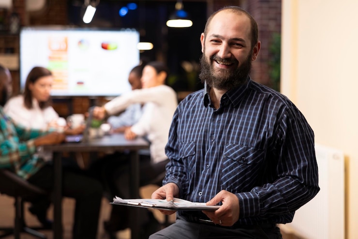 Foto grátis executivo masculino sentado com clipboard no escritório