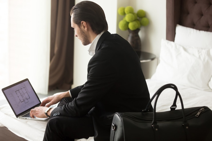 Foto grátis executivo verifica plano imobiliário no laptop no hotel