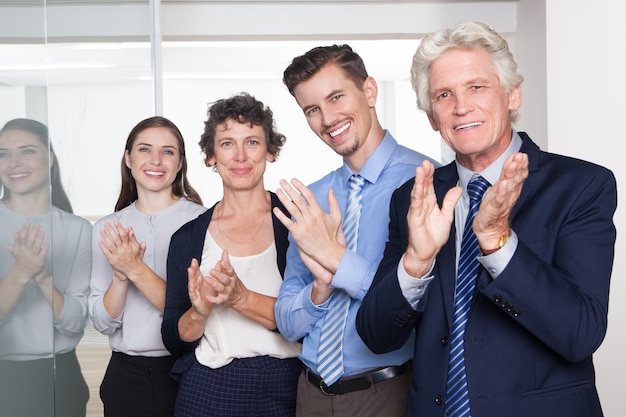 Executivos bem sucedidos sorrindo e aplaudindo