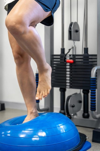 Foto grátis exercício de equilíbrio com a mulher de bola de bosu e em um ginásio