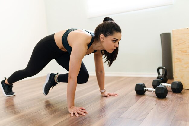 Exercício em casa com um programa de treinamento intervalado de alta intensidade. Mulher fitness fazendo alpinistas e treino cardio