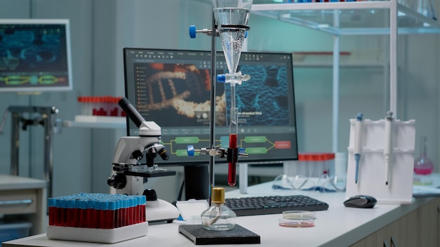 Experiência química com tubo de ensaio em laboratório usado para inovação científica. amostra de sangue em frasco preparado para análise de exame na mesa com vacutainers, pipeta e microscópio Foto Premium