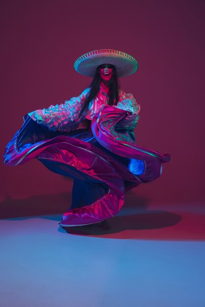 Fabulosa dançarina de Cinco de Mayo na parede roxa com luz de néon.