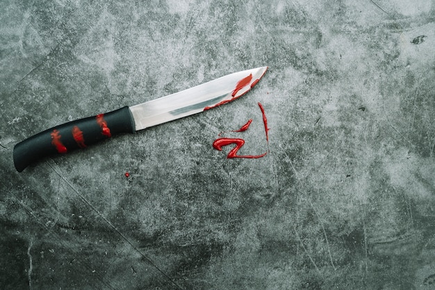 Faca com sangue artificial na mesa de pedra