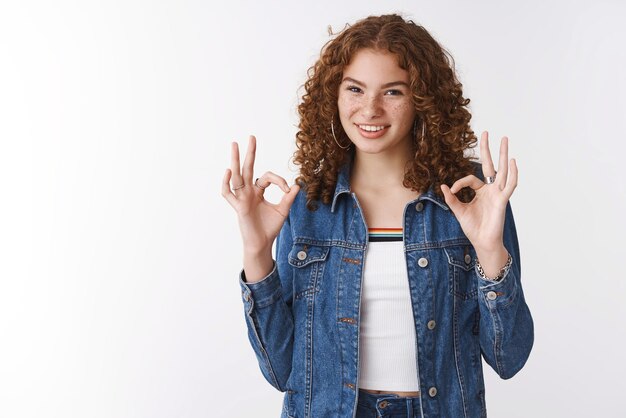 Fácil ok Retrato autoconfiante assertivo bonito ruivo sardas espinhas vestindo jaqueta jeans mostra ok taxa de gestos amigo roupa concorda gostando do produto em pé fundo branco