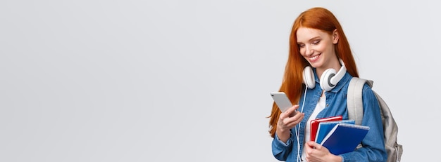 Foto grátis faculdade de adolescentes e conceito de educação atraente estudante universitária ruiva com fones de ouvido