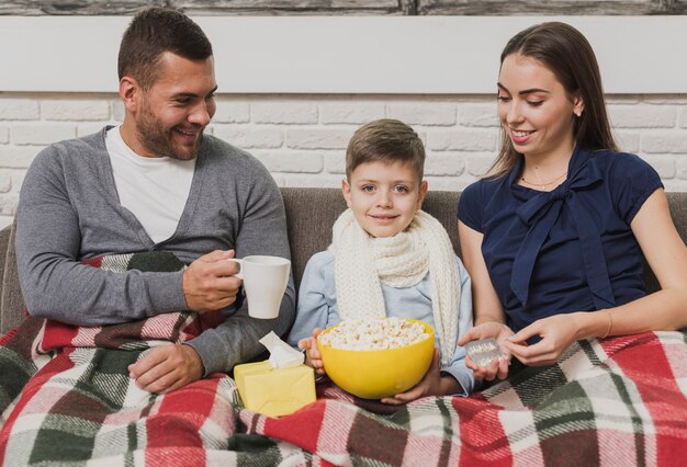 Família adorável com o filho de refrigeração