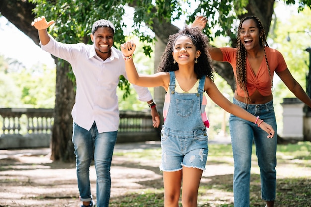 Família afro-americana se divertindo e curtindo um dia juntos ao ar livre no parque.