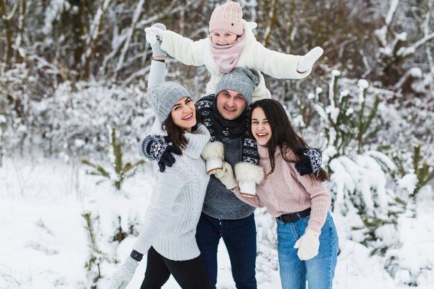 Família alegre na floresta de inverno