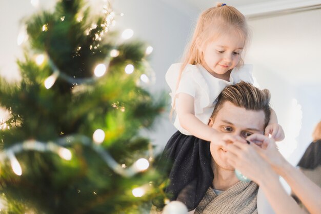 Família ao lado da árvore de Natal iluminada