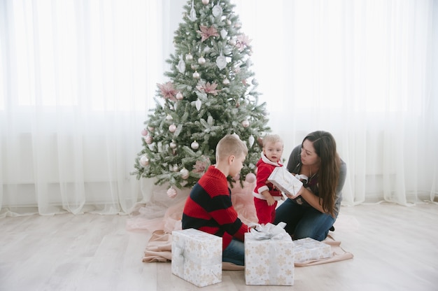 família ao lado da árvore de natal