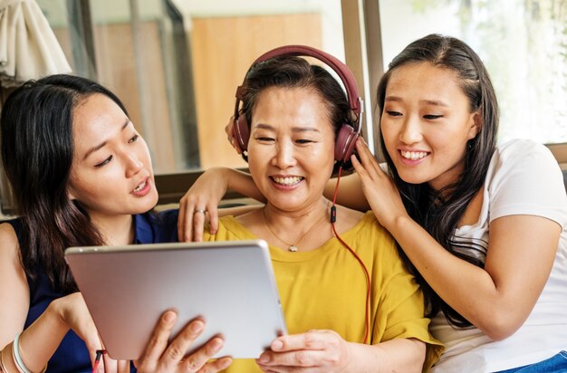 Família asiática está usando tablet digital juntos