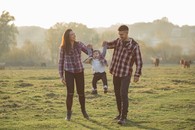 Família bonita andando em um parque por do sol de verão