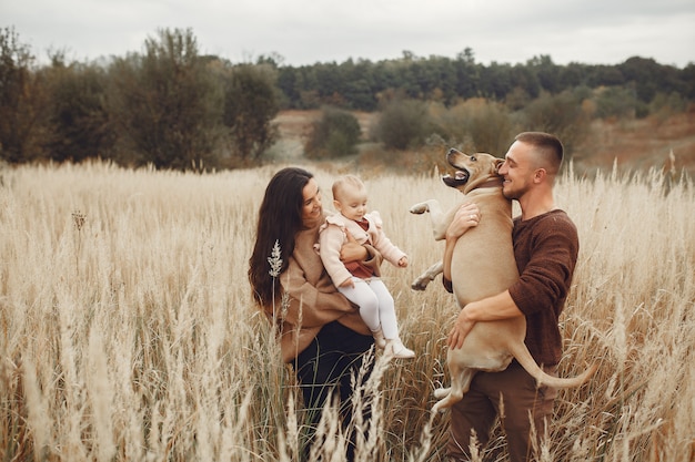 Família bonita e elegante, jogando em um campo de outono