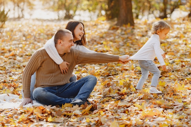 Família bonita e elegante, jogando em um campo de outono