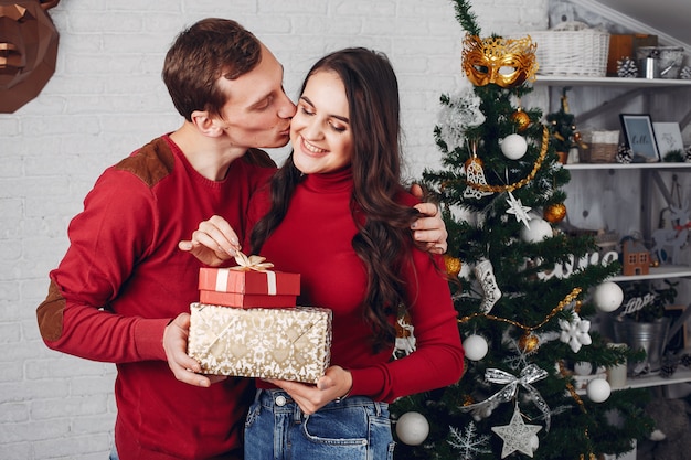 Família bonita em casa perto de árvore de Natal