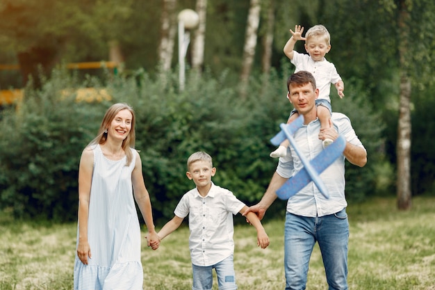 Família caminhando em um campo brincando com um avião de brinquedo