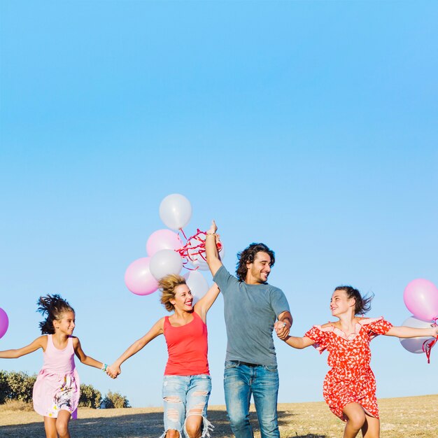 Família com balões se divertindo no campo