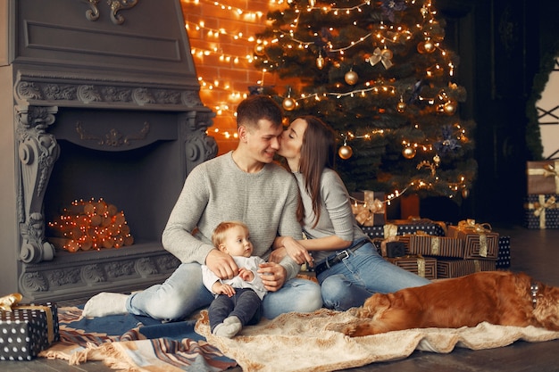 Família com cachorro fofo em casa perto da árvore de natal