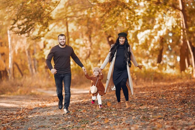 Família com filha em um parque de outono