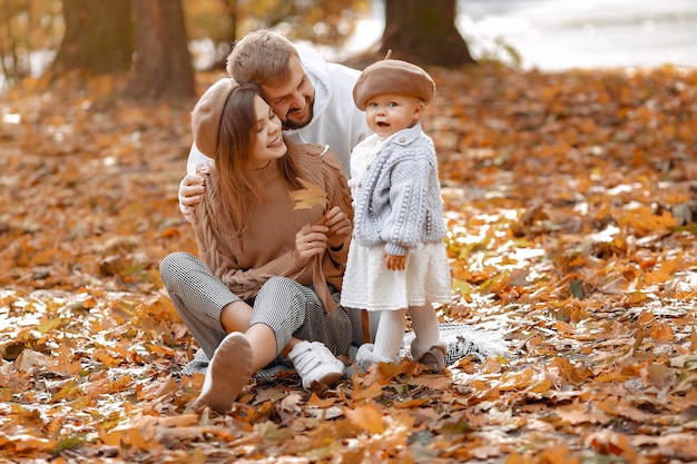 Família com filha em um parque de outono