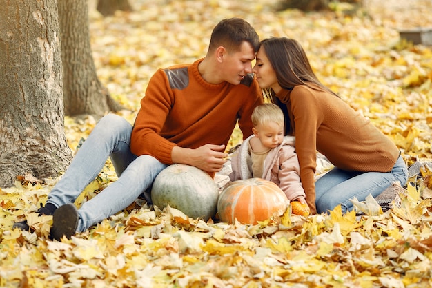 Família com filha em um parque de outono