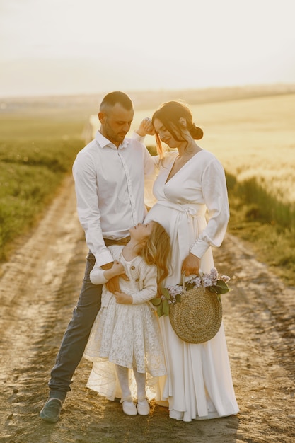 Foto grátis família com filha passando um tempo juntos no campo ensolarado