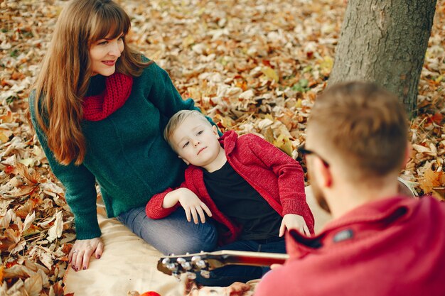 Família com filho pequeno em um parque de outono