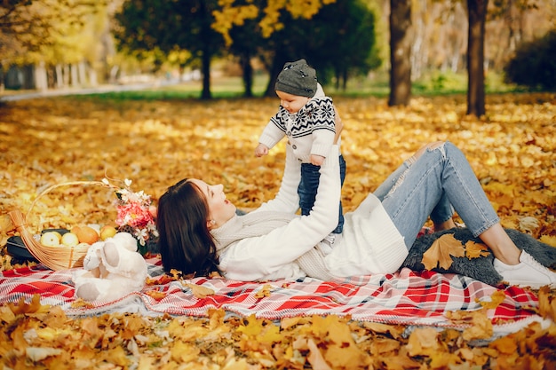 Família com filho pequeno em um parque de outono