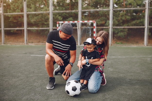 Família com filho pequeno jogando futebol