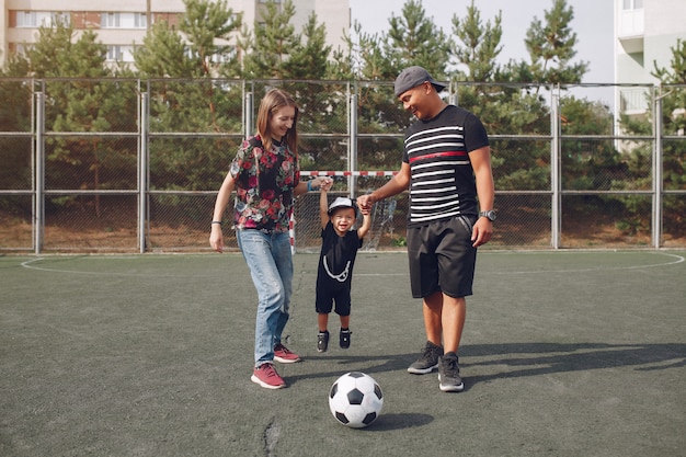 Família com filho pequeno jogando futebol