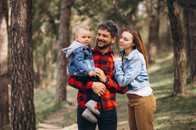 Família com filho pequeno junto na floresta