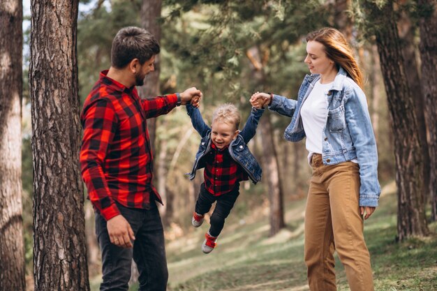 Família com filho pequeno junto na floresta