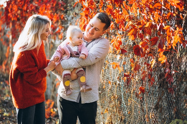 Família com sua filha bebê em um parque de outono