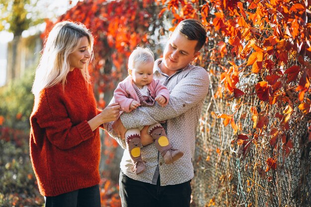 Família com sua filha bebê em um parque de outono