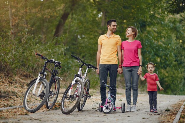 Família com uma bicicleta em um parque de verão