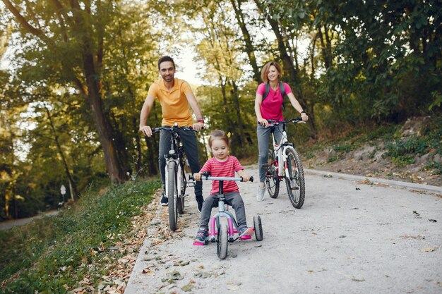 Família com uma bicicleta em um parque de verão