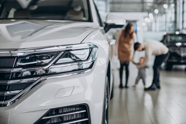 Família com uma menina escolhendo um carro em um salão de automóveis