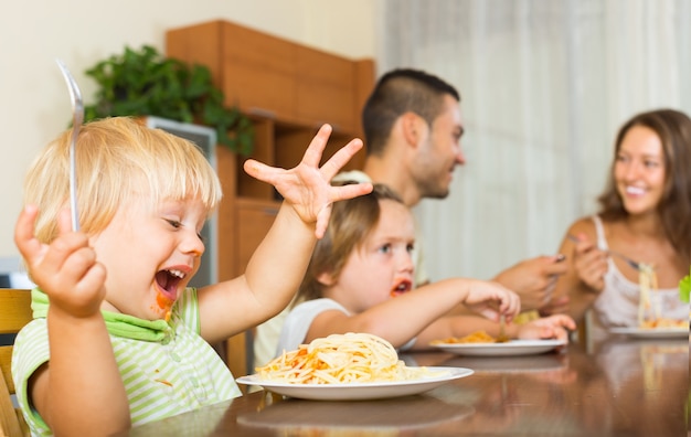 Família de quatro comendo espaguete